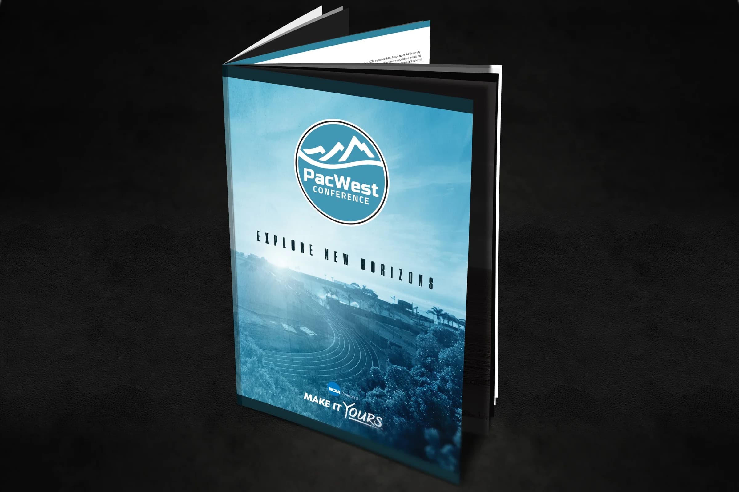 PacWest Conference recruiting brochure standing open on a dark surface, cover reading Explore New Horizons