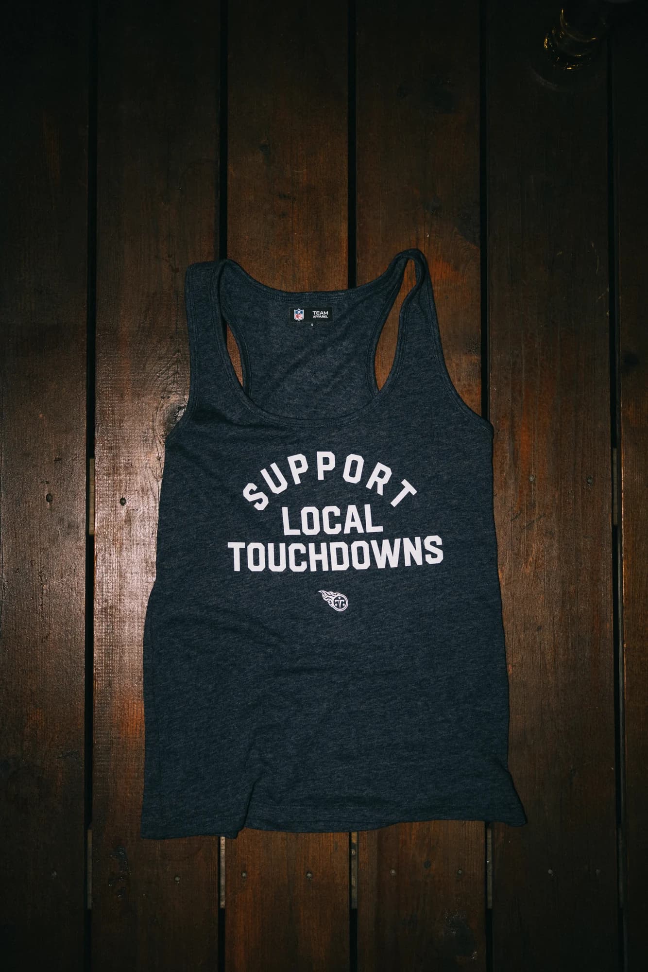 Support Local Touchdowns racerback tank laid flat on wood