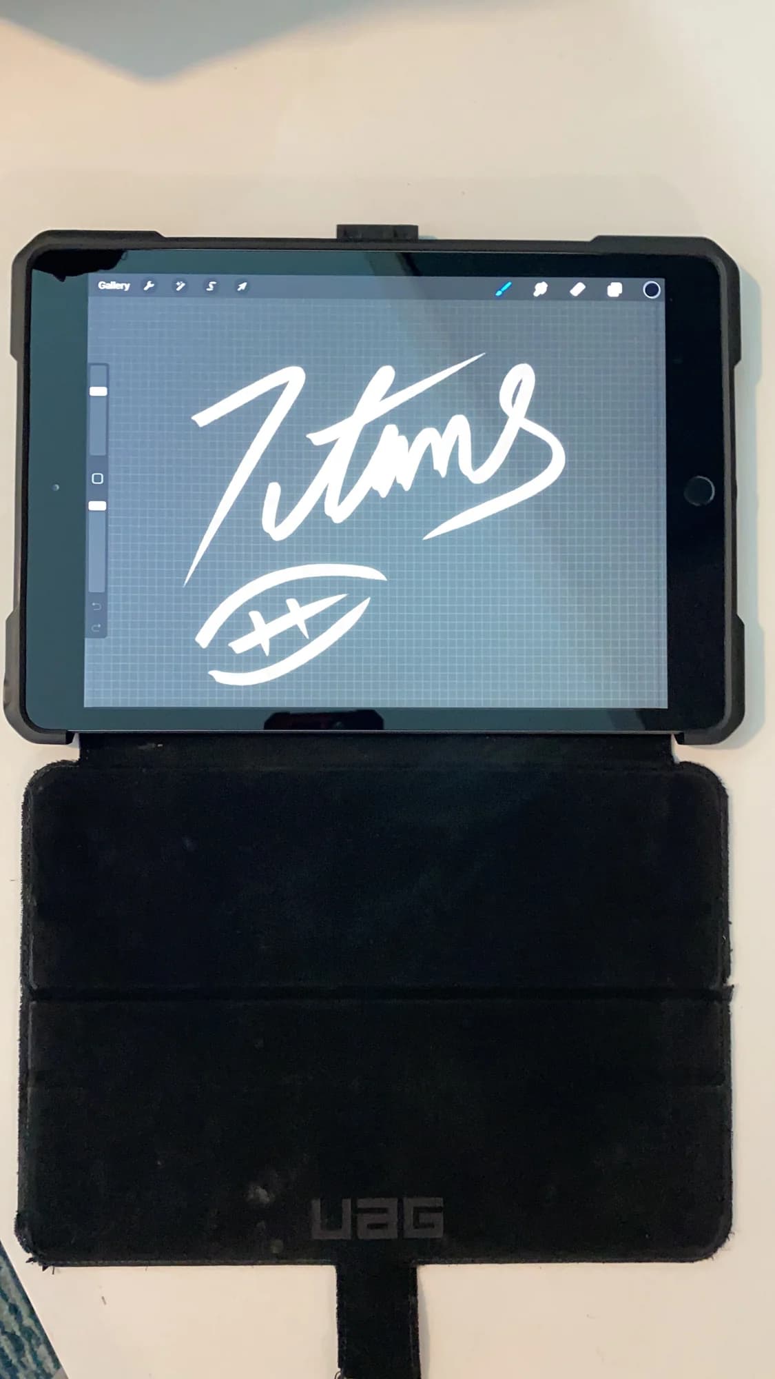 The Titans script mark being drawn by hand on an iPad